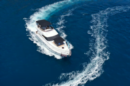 A sleek, modern luxury motor yacht slicing through azure waters during a premium motor yacht charter in the Mediterranean.