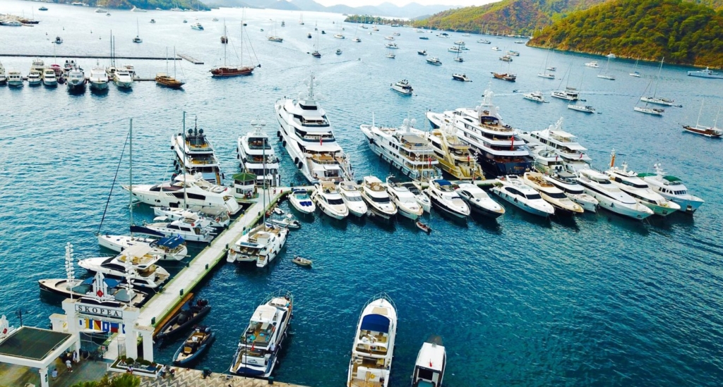 Kapetan i posada šetaju drvenim molovima marine Skopea u Gocek u zalasku sunca.