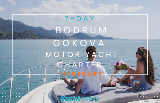 Eine schnittige weiße Motoryacht, die an einem sonnigen Tag im türkisfarbenen Wasser des Golfs von Gökova vor Anker liegt, umgeben von üppigen grünen Pinienwäldern.