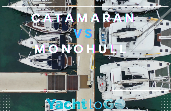A sailing catamaran and a monohull sailing side by side showing hull stability differences.