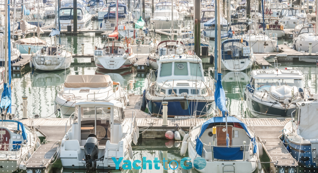 A bareboat catamaran maneuvering tightly in marina, demonstrating where yacht charter costs and security deposits matter most.