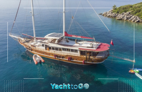 Eine luxuriöse Gulet-Yacht ankert sicher hinter einem felsigen Berg in der Türkei, um dem Meltemi-Wind zu entgehen.