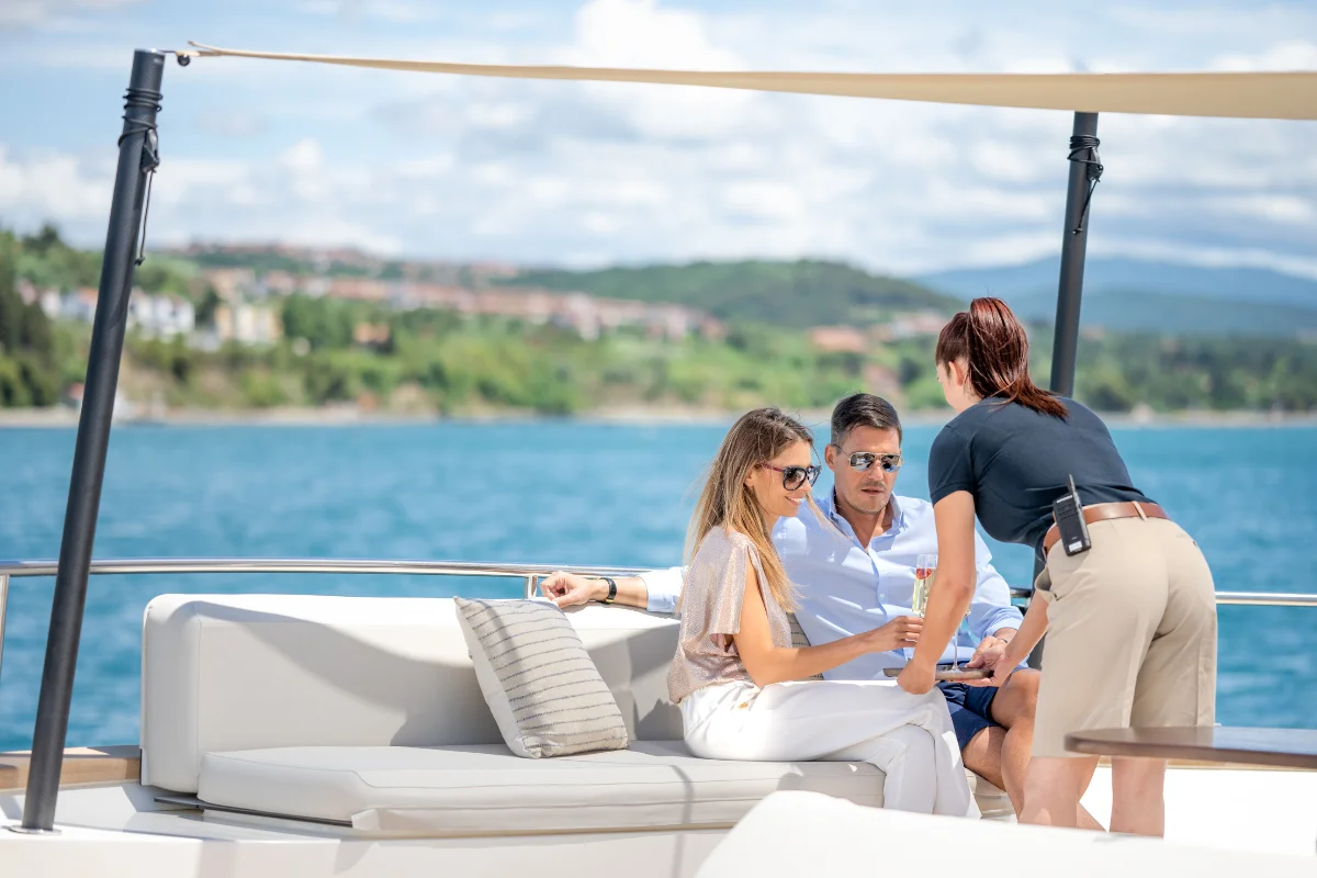 Exclusive Luxury Yacht Charter Champain Turkey Dubai | Yachttogo Professional yacht stewardess serving premium champagne to vip guests, demonstrating 5-star hospitality on a private charter.