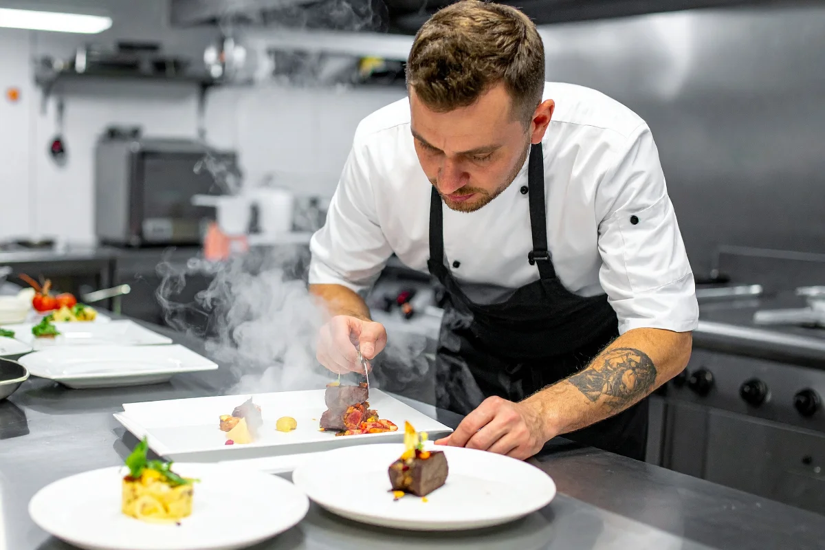 Exclusive Luxury Yacht Charter Chef Turkey Dubai Italy | Yachttogo Professional private chef plating michelin-star quality gourmet food for guests on a luxury yacht charter.