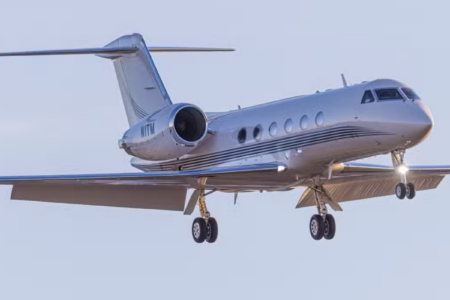 Exterior profile of the gulfstream g4 heavy private jet parked on the tarmac ahead of a vip charter flight.