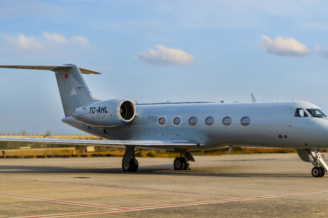 Exterior profile of the Gulfstream G4 heavy private jet parked on the tarmac ahead of a VIP charter flight.