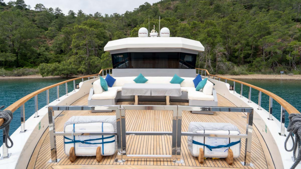 منظر جوي بطائرة بدون طيار ليخت فاخر فاخر يرسو في خليج صغير خاص ومنعزل محاط بأشجار الصنوبر في المياه الفيروزية لبحر إيجه.